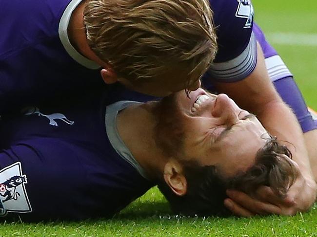 Tottenham Hotspur's English striker Harry Kane (up) attends to Tottenham Hotspur's English midfielder Ryan Mason, as he lies injured after scoring the opening goal of the English Premier League football match between Sunderland and Tottenham Hotspur at the Stadium of Light in Sunderland, north east England on September 13, 2015. Tottenham won the game 1-0. AFP PHOTO / IAN MACNICOL RESTRICTED TO EDITORIAL USE. No use with unauthorized audio, video, data, fixture lists, club/league logos or 'live' services. Online in-match use limited to 75 images, no video emulation. No use in betting, games or single club/league/player publications.