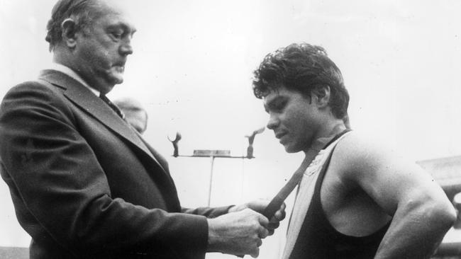 Maurice Rioli receives the Norm Smith Medal in 1982 at the MCG.