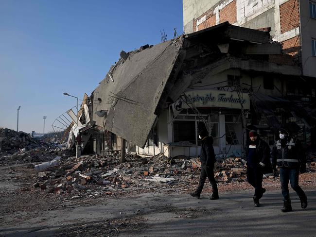 Police officers pass by collapsed buildings in Kahramanmaras, Turkey. Picture: AFP