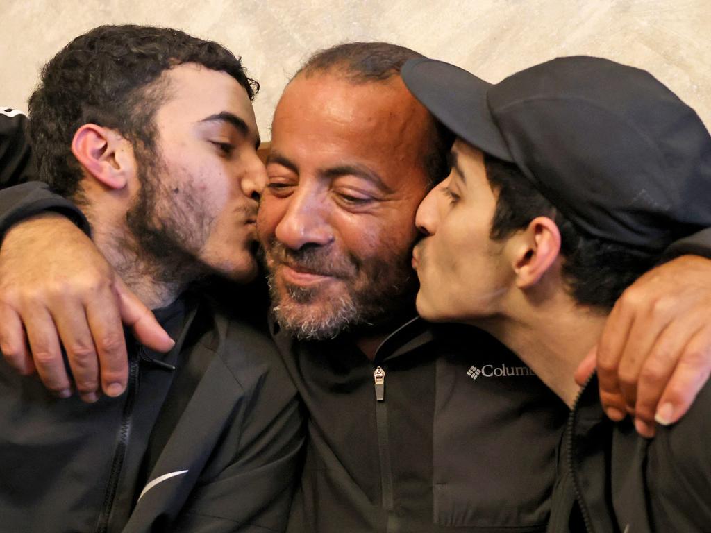 Palestinian brothers Qassam, left, and Nasrallah, right, reunite with their father Iyad Al-Awar after both were released from an Israeli prison as part of a hostage deal. Picture: AFP