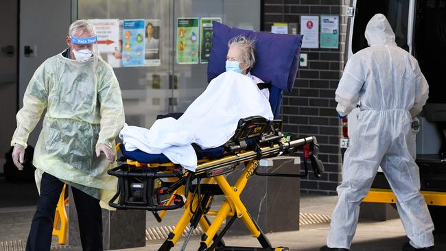 Medical workers evacuate a resident from the Epping Gardens aged care facility in the Melbourne suburb of Epping on July 30, 2020, as the city battles fresh outbreaks of the COVID-19 coronavirus. (Photo by William WEST / AFP)