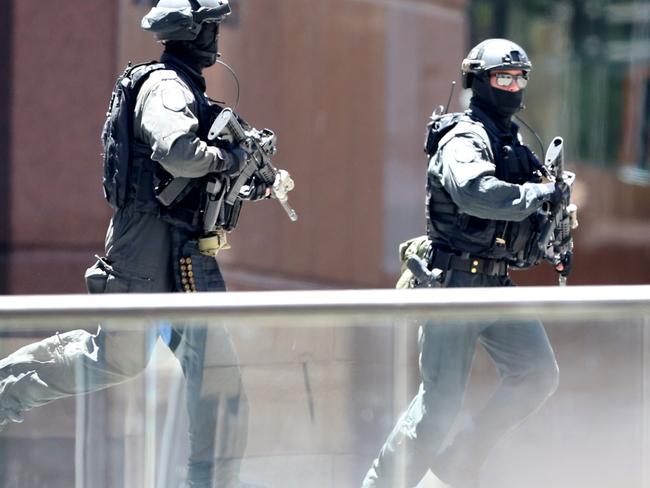 Armed police run into position as news of the siege broke. Picture: adam taylor