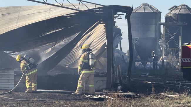 Police extinguish the last few spot fires after allowing the blaze to 'burn through' the highly flammable materials at Anakie. Photo: Ryan Bourke.