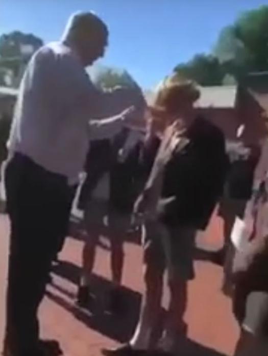 A screen shot from the video showing Mr Brown trimming the student’s hair.