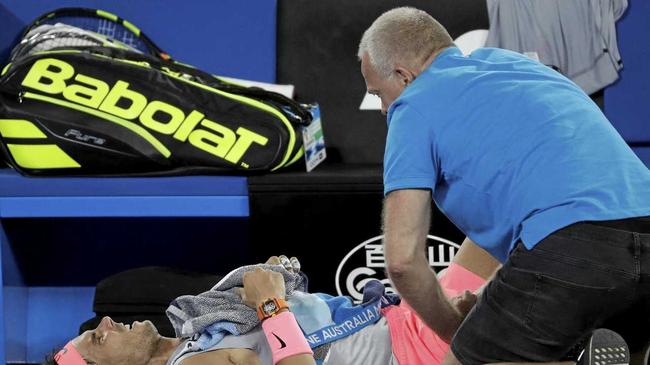 Rafael Nadal receives treatment before pulling out of the Australian Open. Picture: Dita Alangkara