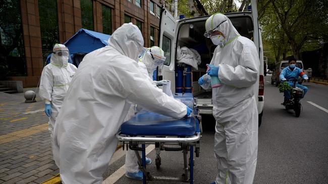 Medical workers disinfect a stretcher in Wuhan. Picture: AFP