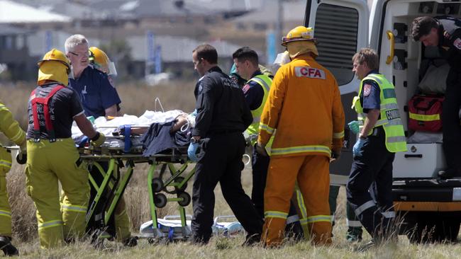 Rescue personnel treat the victim of a car accident on Officer. Picture: Richard Serong