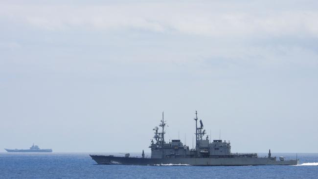 Chinese aircraft carrier Shandong (L) is monitored by a Taiwanese Keelung class warship in the South China Sea. Picture: AFP.