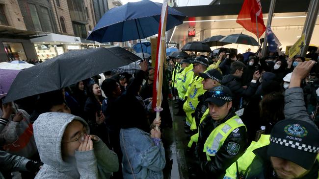 Police form a wall between the pro-democracy Hong Kong supporters and pro-Chinese supporters during a rally in Rundle Mall. Picture: AAP / Kelly Barnes