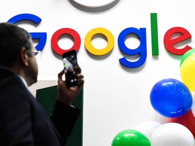 (FILES) In this file photo taken on May 16, 2019 A man takes a picture with his mobile phone of the logo of the US multinational technology and Internet-related services company Google as he visits the Vivatech startups and innovation fair, in Paris. - French Senate approved in the night between May 21 and May 22, 2019 a new tax on digital giants ("Gafa"), such as Google, Amazon, Facebook and Apple, carried through Finance Minister Bruno Le Maire. (Photo by ALAIN JOCARD / AFP)