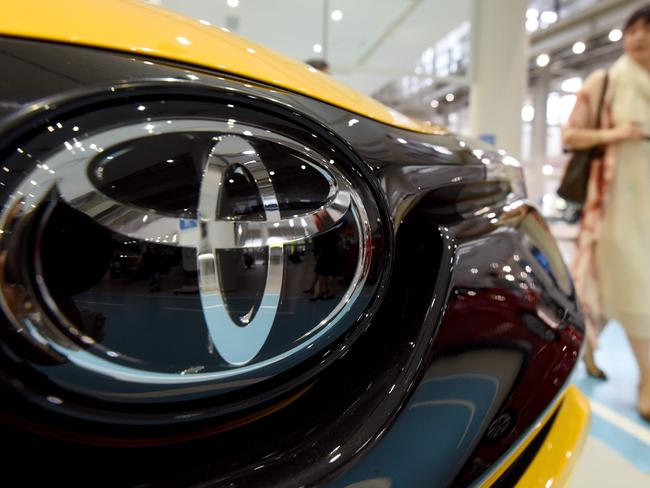 A woman strolls at a showroom of Japan's auto giant Toyota in Tokyo on May 10, 2017. Toyota will release its full-year earnings until March 2017.  / AFP PHOTO / Toru YAMANAKA