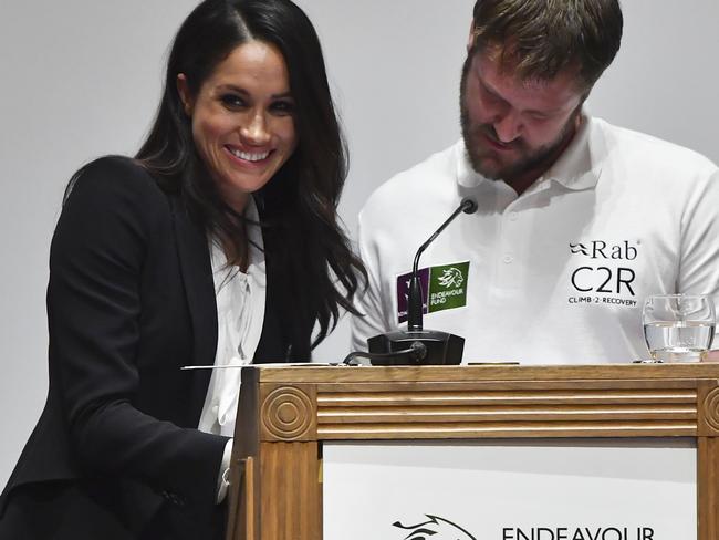 Meghan Markle laughs as her co-presenter struggles with notes at the Endeavour Fund Awards at Goldsmiths' Hall in London. Picture: Ben Stansall/pool via AP