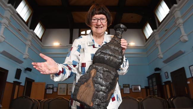 Mary Cahill poses with a part of the ceiling that was burnt in the fire. Picture: Josie Hayden