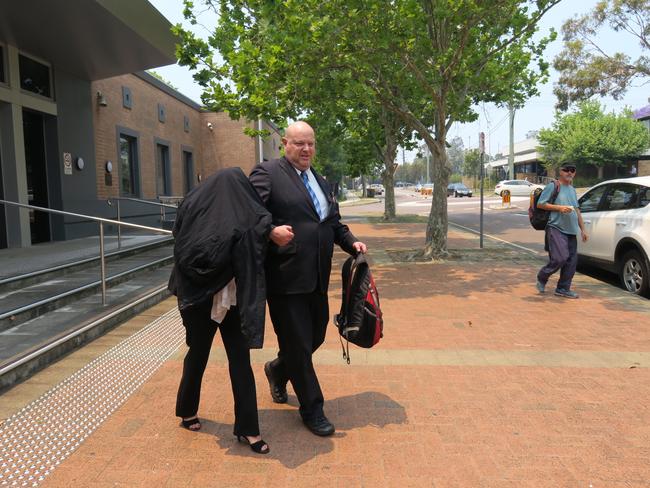 Lisa Curtale (covered) escorted from Wyong Local Court during a previous mention. Picture: Richard Noone