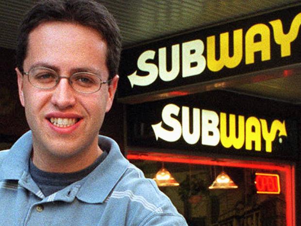 USA formerly overweight obese man Jared Fogle who lost 100 kg in weight after eating Subway sandwiches for one year. Here outside Subway outlet in Sydney holding his old size 61 inch trousers 14 May 2002.