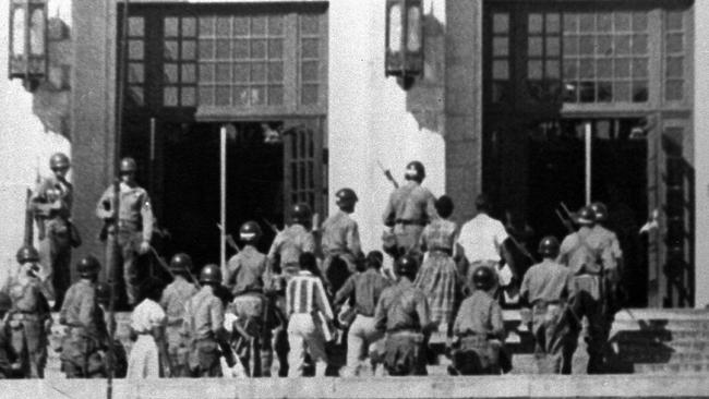 Armed paratroopers escort nine black students into Central High School in Little Rock, Arkansas, on September 25, 1957. US president Eisenhower had decided the day before to send federal troops in to protect black children against white demonstrators.