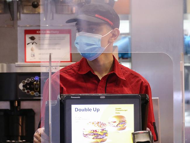 A McDonald’s employee wears a mask in Melbourne. Picture: NCA NewsWire / Ian Currie