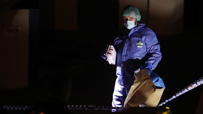 Police at the scene in Chiffley Place Arundel on Wednesday night including an officer with evidence bags. Picture: Glenn Hampson