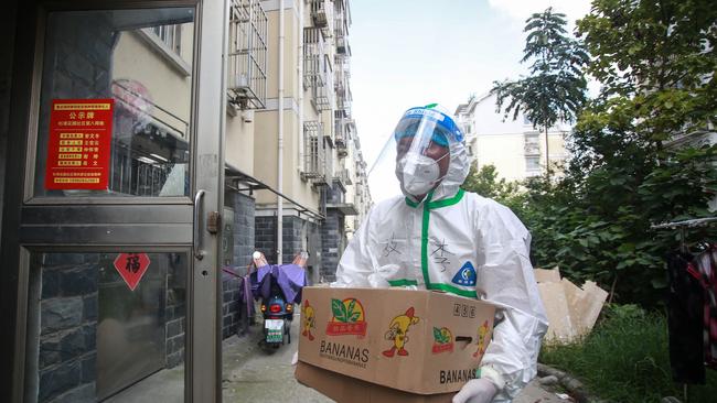 A volunteer delivers food to residents locked down in Yangzhou, in China’s eastern Jiangsu province, on Friday. Picture: AFP