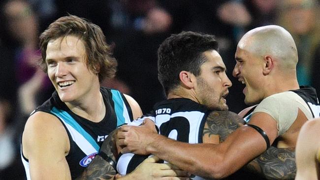 Jared Polec, Chad Wingard and Sam Powell-Pepper celebrate a goal in the Showdown victory. Picture: AAP Image/David Mariuz