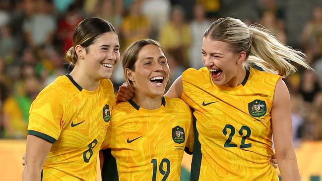 MELBOURNE, AUSTRALIA - FEBRUARY 28: Kyra Cooney-Cross of Australia, Katrina Gorry of Australia and Charlotte Grant of Australia celebrate after winning the AFC Women's Olympic Football Tournament Paris 2024 Asian Qualifier Round 3 match between Australia Matildas and Uzbekistan at Marvel Stadium on February 28, 2024 in Melbourne, Australia. (Photo by Robert Cianflone/Getty Images)