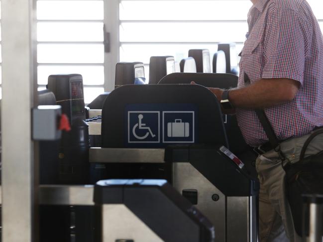 Passengers walk through the turnstiles at Brisbane Domestic Airport Air Train station at Brisbane Domestic Airport Terminal, Eagle Farm on Friday, December 6, 2019. (AAP Image/no byline)