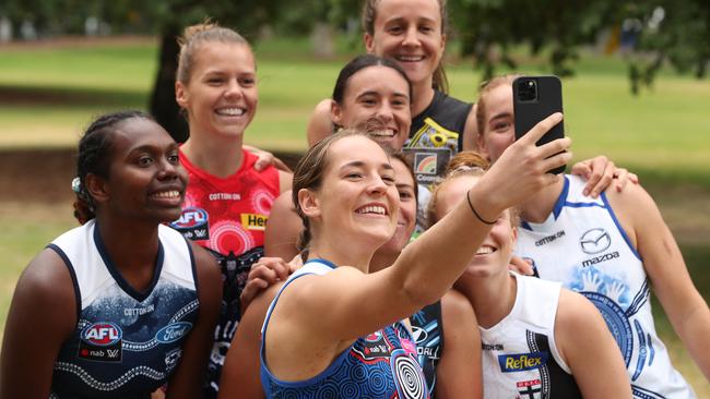 AFLW players take a selfie in their club’s indigenous round jumpers.