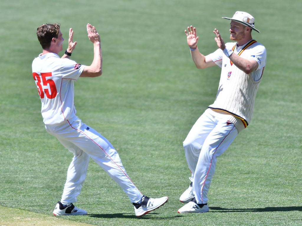 Brendan Doggett (left) celebrates the wicket of Queensland’s Joe Burns with teammate Nathan McAndrew. Picture: Mark Brake/Getty Images