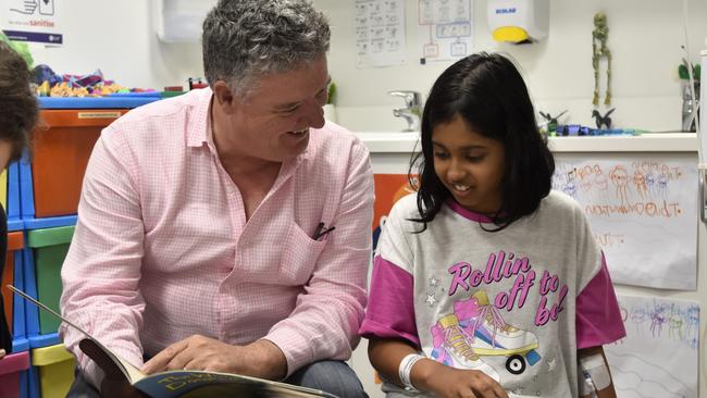 Education Minister Mark Monaghan reads to a Royal Darwin Hospital school student. Picture: Sierra Haigh