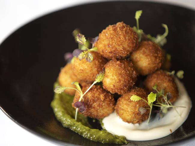 The Astor Grill’s crumbed feta-stuffed olives with a sharp salsa verde. Picture: CHRIS KIDD