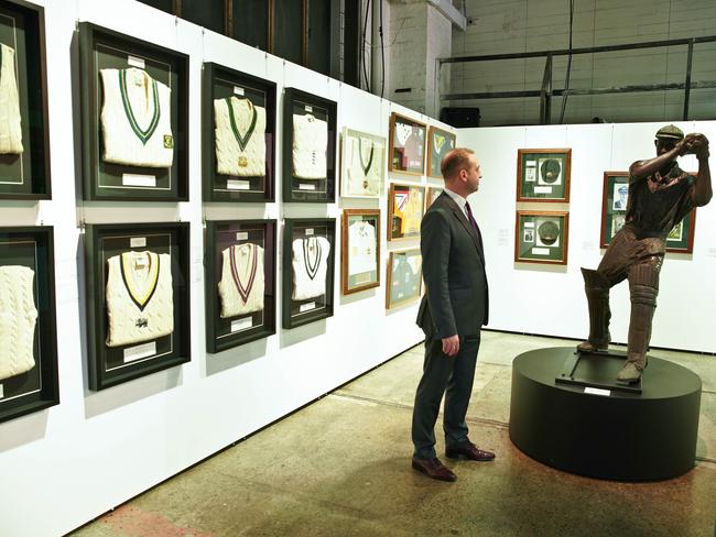 John Keats from Sotheby's Australia stands with cricket items owned by actor Russell Crowe auctioned by Sotheby's auction house. Picture: AAP