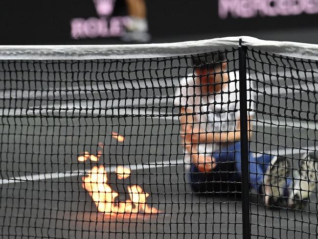 A protester invades the court, appearing set his arm alight during the singles game between Greece's Stefanos Tsitsipas of Team Europe and Argentina's Diego Schwartzman of Team World at the 2022 Laver Cup at the O2 Arena in London on September 23, 2022. (Photo by Glyn KIRK / AFP) / RESTRICTED TO EDITORIAL USE