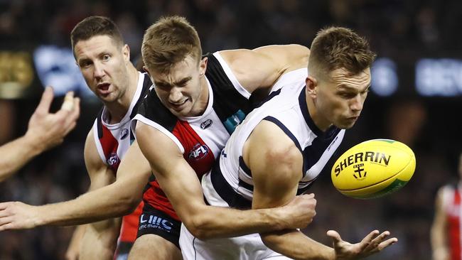 Shaun Higgins of the Cats is tackled by Dougal Howard of the Saints.