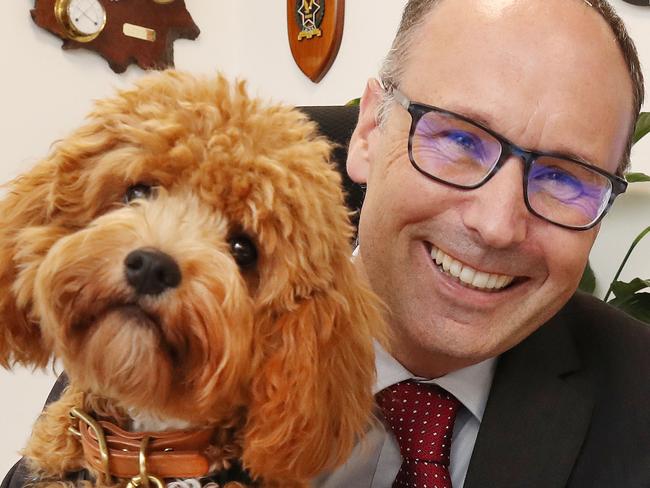 Emmanuel College principal Daniel Brown with therapy dog Mylo in his office. Picture Glenn Hampson