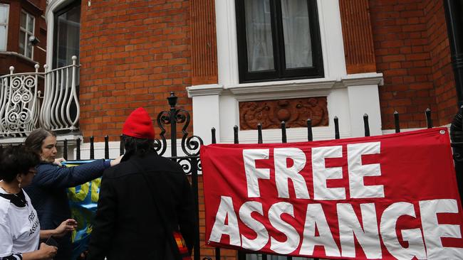 Protesters fix banners outside the Ecuadorean embassy in London. Picture: AP.