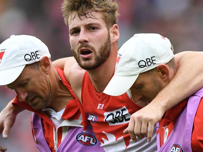 Alex Johnson of the Swans (centre) is seen after sustaining an injury during the Round 21 AFL match between the Melbourne Demons and the Sydney Swans at the MCG in Melbourne, Sunday, August 12, 2018. (AAP Image/Julian Smith) NO ARCHIVING, EDITORIAL USE ONLY