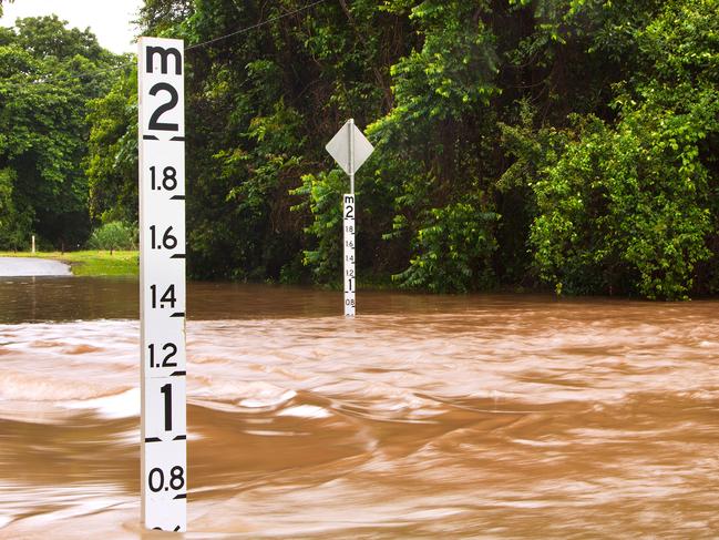 A flooded road with depth indicators in Queensland, Australia