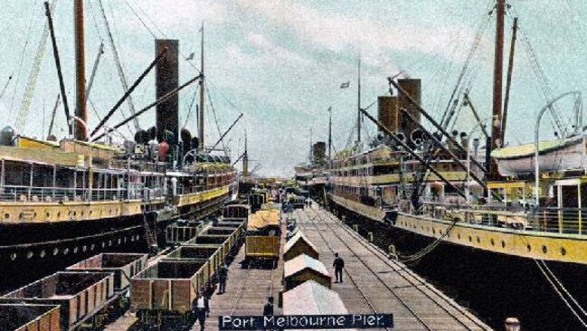 Postcard of Port Melbourne Pier showing cargo being loaded onto trailers to be transported to Melbourne on the Port Melbourne train line in 1907. Picture: Supplied.