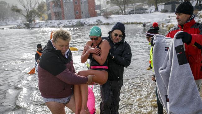 Katya Noble pulled from the water after finishing the ice mile. Picture: Sean Davey.