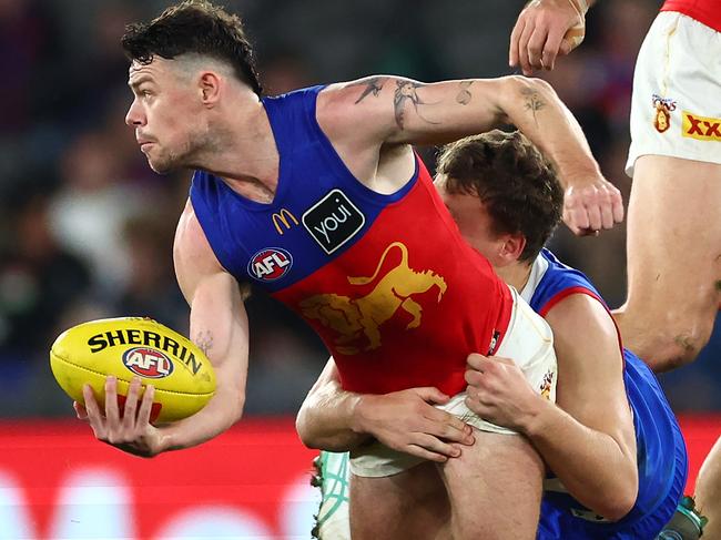 MELBOURNE, AUSTRALIA - JUNE 07: Lachie Neale of the Lions handballs whilst being tackled by Jack Macrae of the Bulldogs during the round 13 AFL match between Western Bulldogs and Brisbane Lions at Marvel Stadium, on June 07, 2024, in Melbourne, Australia. (Photo by Quinn Rooney/Getty Images)