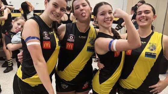 A show of strength. Lucy Riddle, second from the right flexing her muscles, with teammates after the match. Note the blue and white arm bands.