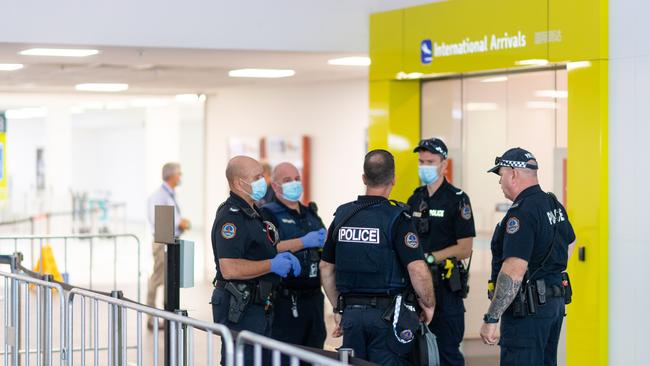 Two flights were arriving at Darwin International Airport from Adelaide today at 9.30am and 9.38am. Pictured are police awaiting the arrival of passengers for transfer to Howard Springs. Picture: Che Chorley