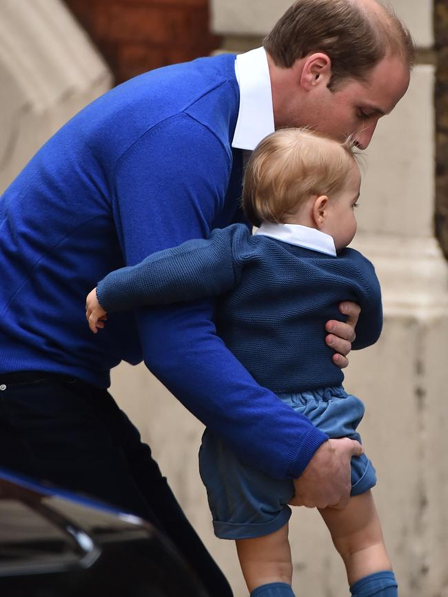 William attempts to place George on the ground, so that he may toddle forth.