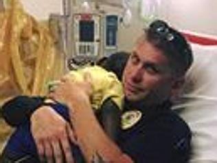 Cop comforts distraught toddler