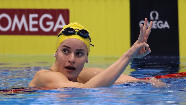 Kaylee McKeown puts up three fingers to celebrate winning the backstroke treble. (Photo by Sarah Stier/Getty Images)