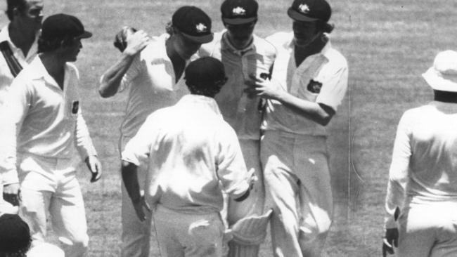 A groggy John Maclean is supported by Kim Hughes, left, as others including Graham Yallop (infront of him, back turned), come to his aid.