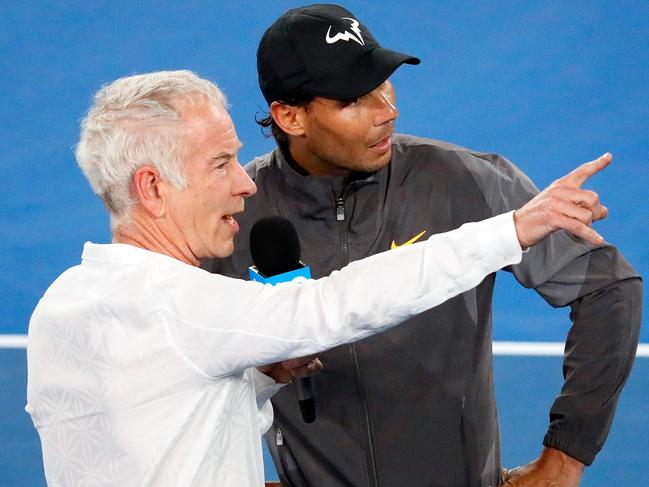 Spain's Rafael Nadal talks to former US tennis player John McEnroe (L) after the men's singles match against Australia's Matthew Ebden on day three of the Australian Open tennis tournament in Melbourne on January 16, 2019. (Photo by DAVID GRAY / AFP) / -- IMAGE RESTRICTED TO EDITORIAL USE - STRICTLY NO COMMERCIAL USE --