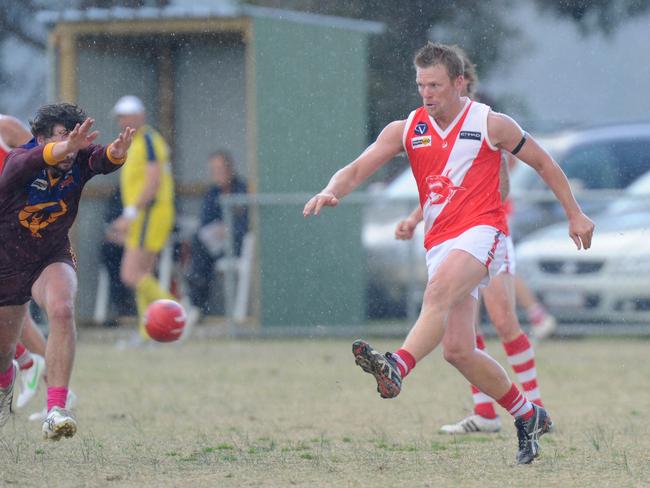 Grant Johnson boots the Sharks forward in heavy rain at Tyabb.