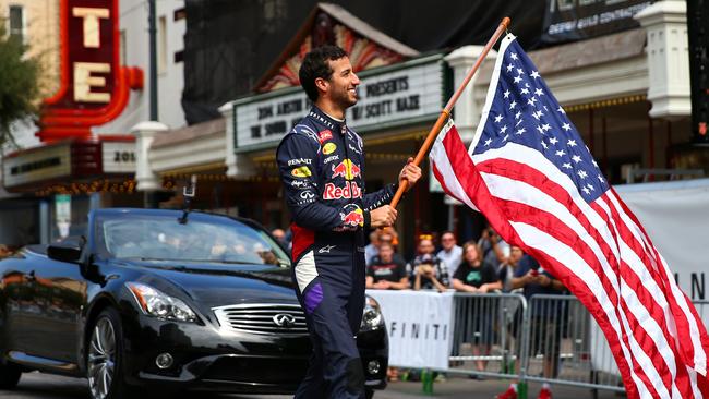 Australian F1 driver Daniel Ricciardo waves a US flag in Austin, Texas, during a parade for the US Grand Prix.