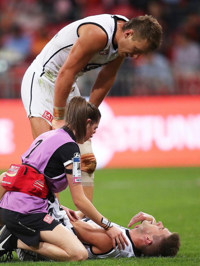 Blues skipper Patrick Cripps checks on his injured teammate. Picture: Phil Hillyard